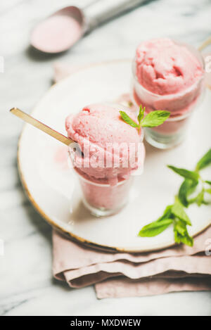 Homemade strawberry yogurt ice cream with mint on plate, vertical composition Stock Photo