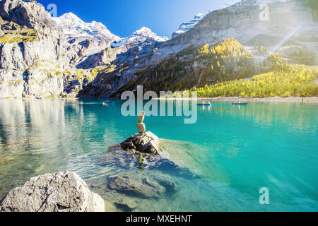 Amazing tourquise Oeschinnensee with waterfalls, wooden chalet and Swiss Alps, Berner Oberland, Switzerland. Stock Photo