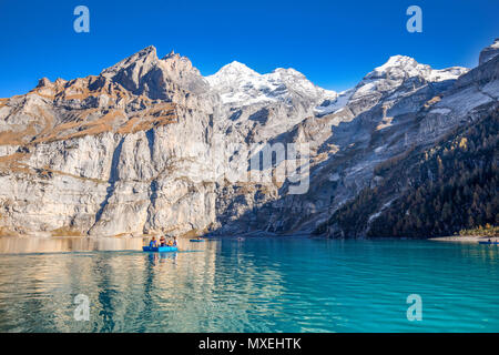 OESCHINENSEE, SWITZERLAND - October 2017 - Amazing tourquise Oeschinnensee with waterfalls, wooden chalet and Swiss Alps, Berner Oberland, Switzerland Stock Photo