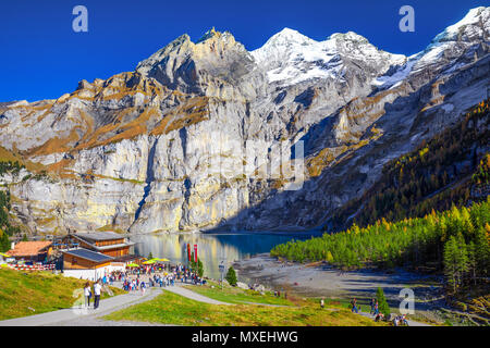 OESCHINENSEE, SWITZERLAND - October 2017 - Amazing tourquise Oeschinnensee with waterfalls, wooden chalet and Swiss Alps, Berner Oberland, Switzerland