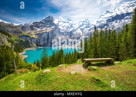 Amazing tourquise Oeschinnensee with waterfalls, wooden chalet and Swiss Alps, Berner Oberland, Switzerland. Stock Photo