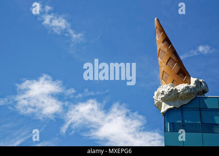 sculpture of an ice cream cone on the roof of shopping center