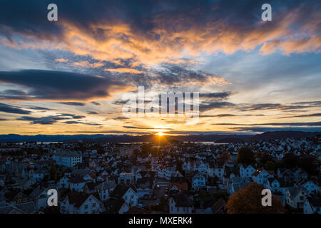 Sun rising behind mountains shining at clouds Stock Photo