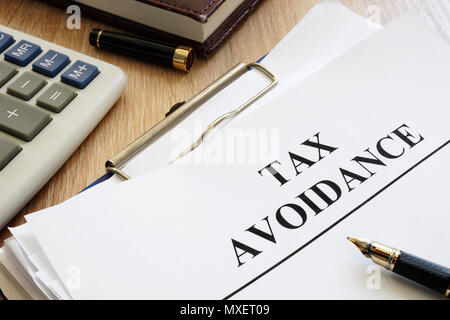 Documents about tax avoidance on a desk. Stock Photo