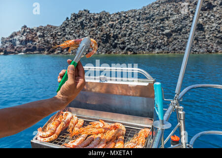 Cooking shrimp on the grill during the cruise Stock Photo