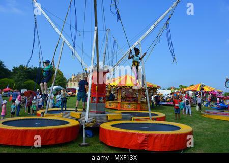 Children bungee jumping at the annual Sherborne Castle Country Fair, Sherborne, Dorset, England. Stock Photo