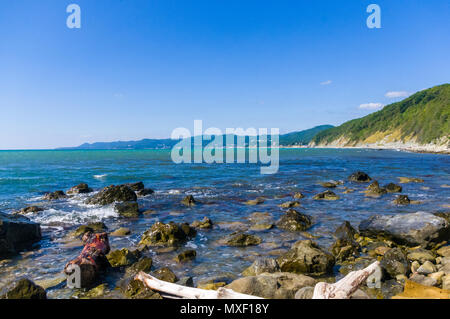 rocky sea shore with pebble beach, waves with foam Stock Photo