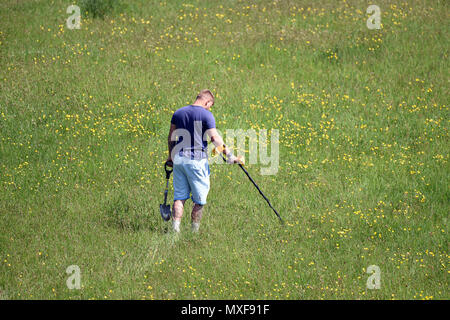 Man using a metal detector on a nature reserve England Uk Stock Photo