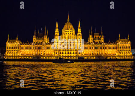 View on Danube river and the illuminated building of Parliament from viewpoint on  a touristic motor ship at night in Budapest, Hungary Stock Photo