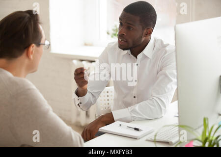 African American mentor explaining new idea to Caucasian employe Stock Photo