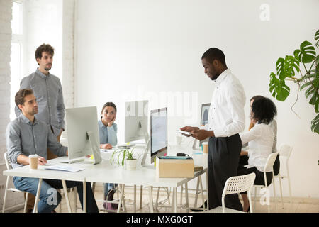 Dismissed black worker packing personal belongings into box Stock Photo