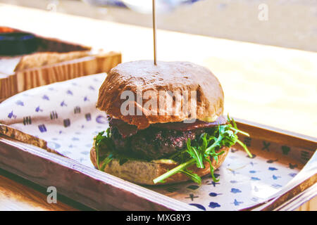 Tasty burger on wooden board of restorant in vintage style Stock Photo