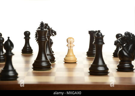 Pawn chess pawn surrounded by black opponents isolated on a white background Stock Photo