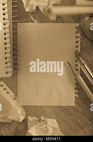 Empty crumpled pages and notebook lying on wooden surface Stock Photo