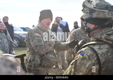 YAVORIV, Ukraine—Army Staff Sgt. David Martin assigned to 6th Squadron, 8th Cavalry Regiment, 2nd Infantry Brigade Combat Team, 3rd Infantry Division teach Ukrainian Soldiers assigned to 1st Battalion, 80th Air Mobile Brigade on the proper way of entering and clearing a room, Nov. 5, at the International Peacekeeping and Security Center. This training is one of the collective tasks that the Ukrainian battalion must accomplish during their 55-day rotation with the Joint Multinational Training Group-Ukraine. JMTG-U’s focus is to build a sustainable, enduring training capacity and capability with Stock Photo