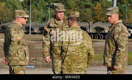 (left to right) U.S. Army Command Sgt. Maj. Christopher Gunn, senior enlisted advisor, 3rd Armored Brigade Combat Team, 4th Infantry Division, discusses different motor pool capabilities with Brig. Gen. Kenneth L. Kamper, deputy commanding general, 4th Inf. Div., Lt. Col. Brian Ketz (front), commander, 16th Special Troops Battalion and Col. Christopher Norrie, commander, 3rd ABCT, during their pre-deployment site survey at Camp Karliki, in Zagan, Poland, Nov. 3, 2016. The survey was part of the pre-deployment stage for Fort Carson, Colorado, units as its leaders view locations throughout Polan Stock Photo