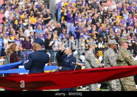 Service members with Joint Task Force - National Capital Region (JTF-NCR) and the Maryland National Guard hold flags during the playing of the national anthem at the Baltimore Ravens’ 'Salute to Service' pre-game ceremony at M&T Bank Stadium, Baltimore, Md., Nov. 6, 2016. JTF-NCR is a joint service command charged with coordinating all military ceremonial support for the 58th Presidential Inauguration. (U.S. Army Photo by Staff Sgt. Elvis Umanzor) Stock Photo