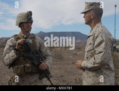 U.S. Marine Corps Maj. Gen. John K. Love, commanding general, 2nd Marine Division (2d MARDIV), speaks with Gunnery Sgt. Matthew D. Harrington, Headquarters Company, 1st Battalion, 2nd Marine Regiment (1/2), 2d MARDIV, on Twentynine Palms, Calif., Nov. 2, 2016. The Marines of 1/2 conducted battalion attacks during the final exercise of Integrated Training Exercise (ITX) 1-17 in preparation for the upcoming Special Purpose Marine Air-Ground Task Force. (U.S. Marine Corps photo by Lance Cpl. Sarah N. Petrock) Stock Photo