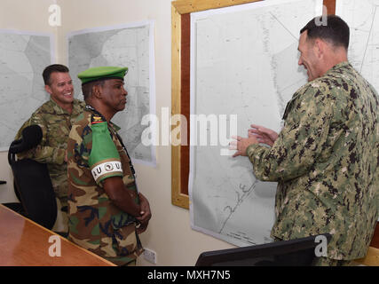 U.S. Army Col. Kyle Reed, Military Coordination Cell Mogadishu director, right, Lt. Gen. Osman Soubagleh, the force commander of African Union Mission in Somalia (AMISOM), center, and U.S. Navy Rear Adm. William Wheeler III, deputy commander of Combined Joint Task Force-Horn of Africa (CJTF-HOA), partake in a light moment during a meeting in Mogadishu, Somalia, Nov. 2, 2016. The venue allowed members to discuss security situations, AMISOM challenges, and the current dynamics seen by both sides. These meetings align with the CJTF-HOA mission of supporting and enabling the stabilization of Somal Stock Photo