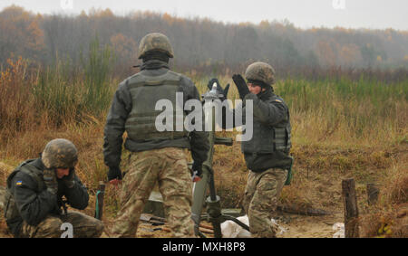 YAVORIV, Ukraine—A Ukrainian Soldier assigned to 1st Battalion, 80th Airmobile Brigade loads a 120mm round into a mortar system, Nov. 9, before a direct lay training, live-fire exercise at the International Peacekeeping and Security Center. The training exercise was observed/controlled by Soldiers assigned to 6th Squadron, 8th Cavalry Regiment, 2nd Infantry Brigade Combat Team, 3rd Infantry Division, along with Polish and Ukrainian instructors, as part of the Joint Multinational Training Group-Ukraine. JMTG-U’s mission is aimed at developing defensive skills and improving Ukraine’s capacity fo Stock Photo