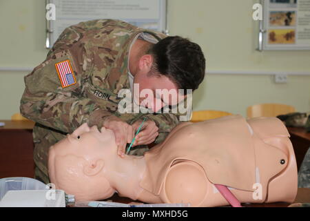 YAVORIV, Ukraine - Spc. Brandon Horn, a medic with 6th Squadron, 8th Cavalry Regiment, 2nd Infantry Brigade Combat Team, 3rd Infantry Division performs a cricothyroidotomy on a mannequin to establish an effective airway during Emergency Medical Technician training here, November 8, 2016. 6-8 CAV is deployed in support of Joint Multinational Training Group-Ukraine whose mission focuses on building a sustainable and enduring training capacity and capability within the Ukrainian land forces.  (U.S.Army photo by Spc. John Onuoha / Released)