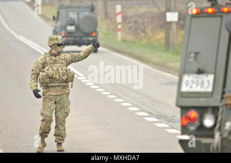 U.S. Army 1st Lt. Alexander G. Canacci, Paratrooper, Company D, 2nd Battalion, 503rd Infantry Regiment, 173rd Airborne Brigade, directs traffic during a Polish Independence Day parade involving his unit, Canadian soldiers assigned to 1st Battalion, Princess Patricia Canadian Light Infantry, and Polish soldiers (not pictured) throughout the township of Drawsko Pomorskie, Poland, Nov. 11, 2016. The Troops helped their Polish counterparts celebrate the country's national holiday that commemorates the anniversary of the restoration of Poland's sovereignty as the Second Polish Republic in 1918. (U. Stock Photo