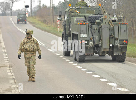 U.S. Army 1st Lt. Alexander G. Canacci, Paratrooper, Company D, 2nd Battalion, 503rd Infantry Regiment, 173rd Airborne Brigade, directs traffic during a Polish Independence Day parade involving his unit, Canadian soldiers assigned to 1st Battalion, Princess Patricia Canadian Light Infantry, and Polish soldiers (not pictured) throughout the township of Drawsko Pomorskie, Poland, Nov. 11, 2016. The Troops helped their Polish counterparts celebrate the country's national holiday that commemorates the anniversary of the restoration of Poland's sovereignty as the Second Polish Republic in 1918. (U. Stock Photo