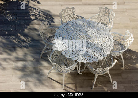 A set of wrought iron outdoor chairs and table standing in a shopping centre. Stock Photo