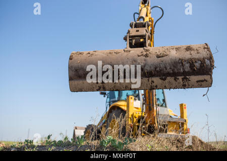 Backhoe tractor working with back long shovel. The machine is prepare the ground Stock Photo