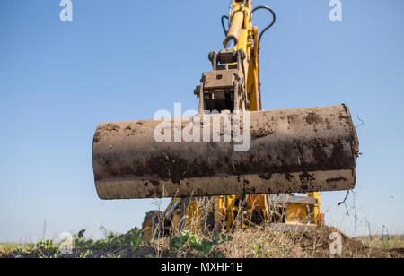 Backhoe tractor working with back long shovel. The machine is prepare the ground Stock Photo