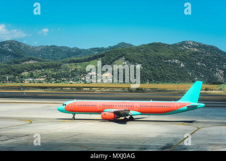 Beautiful airplane on the runway in Dalaman airport in Turkey. Landscape with passenger aircraft is taking off and mountains at bright sunny day in su Stock Photo
