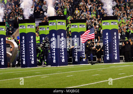 Staff Sgt. John McLaughlin leads the Seattle Seahawks onto the field during  the pregame show at