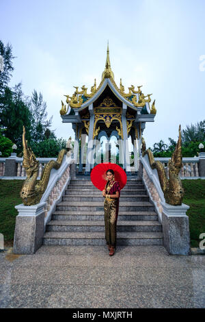 Beautiful Woman with Thai Traditional Dress King Rama posing near the temple Stock Photo
