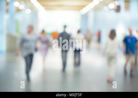 silhouettes of people as they move through the mal with light background. Blured background Stock Photo