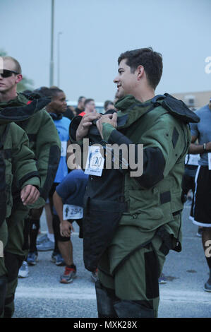 Spc. Cory Brunt, a Soldier with Joint Task Force Atlas (Counter-Improvised Explosive Devices), Combined Joined Task Force-Operation Inherent Resolve, chats with other runners before the Explosive Ordnance Disposal memorial 5k run, May 5, Camp Arifjan, Kuwait. Brunt and three other Soldiers with Task Force Atlas chose to run the 5k in bomb suits to honor other EOD technicians who have fallen. The 5k was held to commemorate and shadow the EOD memorial ceremony held at Eglin Air Force Base, Florida. Stock Photo