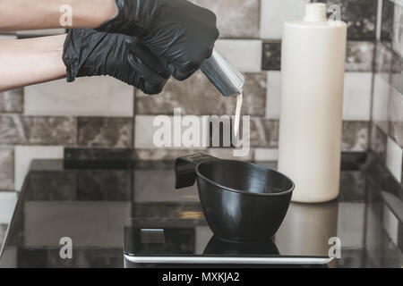 Stylist squeezing a hair dye in a bowl, Hair dyeing at home or in hairdresser salon concept Stock Photo