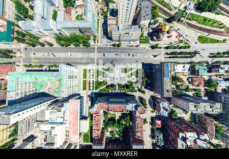 Aerial city view with crossroads and roads, houses, buildings, parks and parking lots. Sunny summer panoramic image Stock Photo