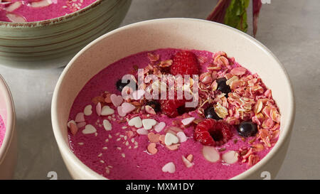 Bowl with breakfast pink smoothie from granola and almond. Stock Photo
