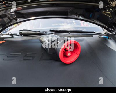 URMOND, NETHERLANDS - MAY 31, 2018. Charging cable for electric motor Type2 'MENNEKES' cable 22KW 32A. Tesla supercharge station with a car on chargin Stock Photo