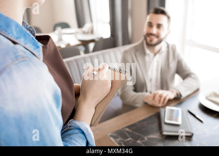 Waitress writing order of customer in cafe Stock Photo