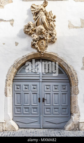 Vintage wooden entry door decorated with carved sculptures Stock Photo