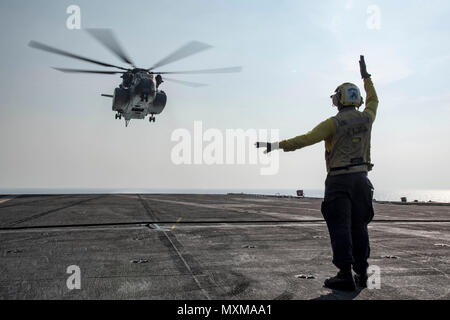161117-N-KK394-062    ARABIAN GULF (Nov. 17, 2016) Petty Officer 3rd Class Joshua Broadbent signals to an MH-53E Sea Dragon helicopter assigned to the Blackhawks of Helicopter Mine Countermeasures Squadron (HM) 15 on the flight deck of the aircraft carrier USS Dwight D. Eisenhower (CVN 69) (Ike). Broadbent serves aboard Ike as an aviation boatswain's mate (handling). Ike and its carrier strike group are deployed in support of Operation Inherent Resolve, maritime security operations and theater security cooperation efforts in the U.S. 5th Fleet area of operations. (U.S. Navy photo by Petty Offi Stock Photo