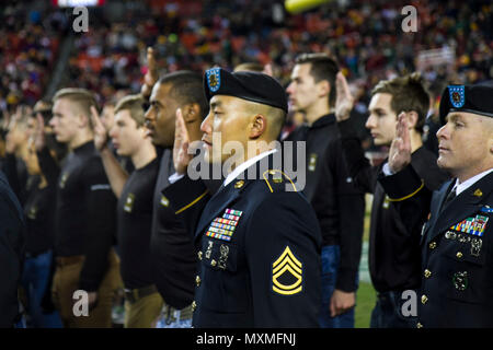 Sgt. 1st Class Jason Lee, a transportation noncommissionsed officer with the 200th Military Police Command, takes the oath of enlistment with a group of various other Soldiers during the NFL military appreciation game at Fedex Field in Landover, Maryland, Nov. 20. Prior to the enlistment ceremony, U.S. Army Reserve and Active Duty Military Police Soldiers showcased military vehicles and aircraft, as well as military working dogs. The 200th MP Command had several HMMWVs and an armored security vehicle on display, providing the public an opportunity to learn more about the MP career field. (U.S. Stock Photo