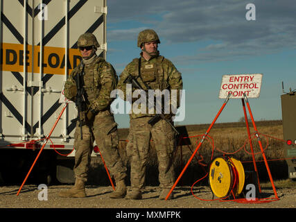 (From left) Senior Airman Dustin Silc and Staff Sgt. Tyler Chronister, 791st Missile Security Forces Squadron convoy response force members, provide security at an entry control point during a recapture and recovery exercise at the missile complex, N.D., Nov. 16, 2016. A cordon was set as part of a simulated hostile takeover training exercise. (U.S. Air Force photo/Senior Airman Apryl Hall) Stock Photo