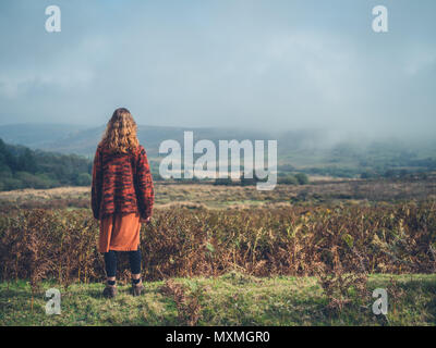 A young woman is standing on a moor in the autumn Stock Photo