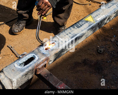 Metal work. Man cuts a hole in a steel piece using gas welding Stock Photo