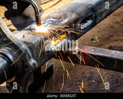 Metal work. Man cuts a hole in a steel piece using gas welding Stock Photo