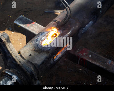 Metal work. Man cuts a hole in a steel piece using gas welding Stock Photo