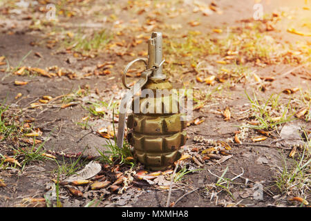 grenade lying on the ground. Hand grenade F-1. abandoned lost pomegranate greenfragmentation grenade. Stock Photo