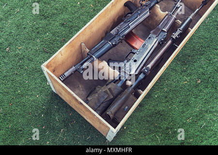 army box of ammunition with AK47 rifle and ammunition. An automatic weapon with a sniper scope in wood box Stock Photo